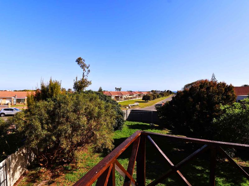 Elevated view overlooking the surrounding residential neighborhood and garden area from a wooden balcony.