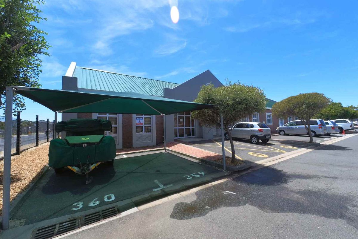 Front exterior view of the office building featuring dedicated shaded parking bays, brick facade, and metal roofing.