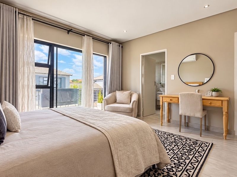 A well-maintained bedroom featuring tiled floors, recessed lighting, built-in wardrobes, and direct access to a private balcony through sliding glass doors.