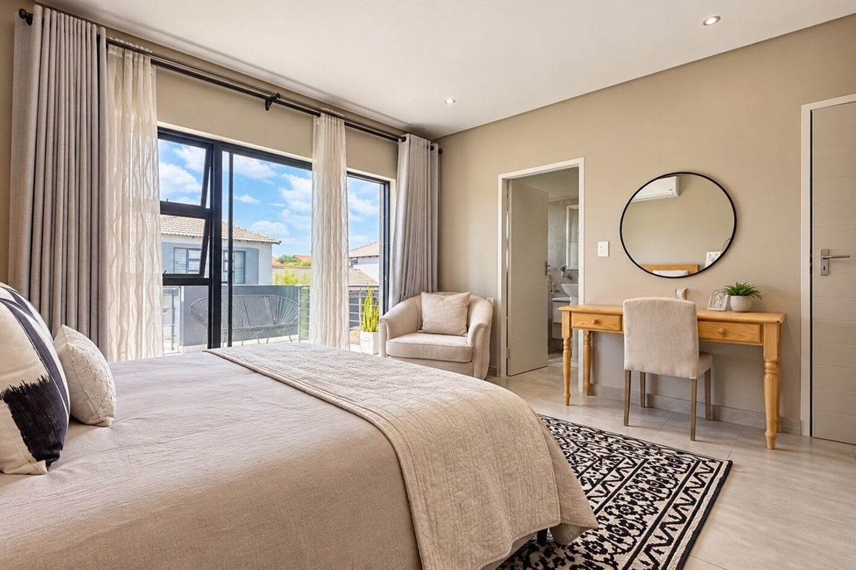 A well-maintained bedroom featuring tiled floors, recessed lighting, built-in wardrobes, and direct access to a private balcony through sliding glass doors.