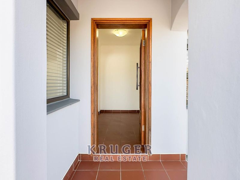 A clean and simple entrance area featuring tiled flooring and a timber door frame leading into the interior of the home.