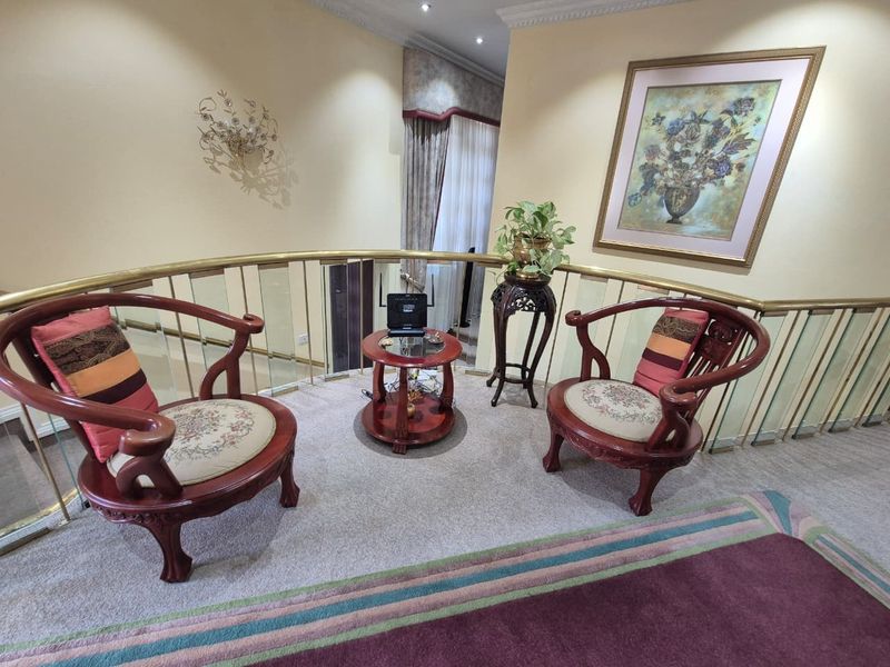 A landing or hallway area featuring a decorative brass and glass balustrade, recessed lighting, and classic coving detail.