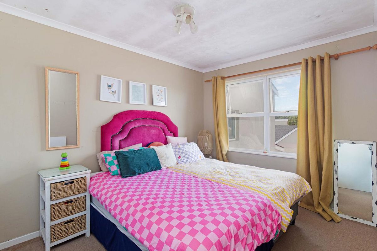 A bedroom featuring carpeted flooring, a window with curtain rod, and ceiling coving. The ceiling shows visible signs of staining and plaster damage.