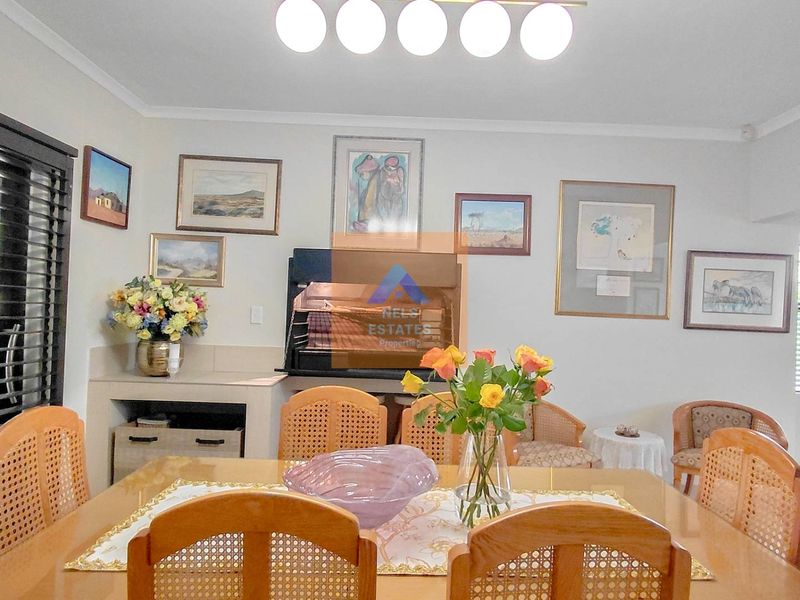 Dining room featuring a built-in indoor braai, tiled flooring, and slatted window blinds, providing a functional space for indoor entertaining.