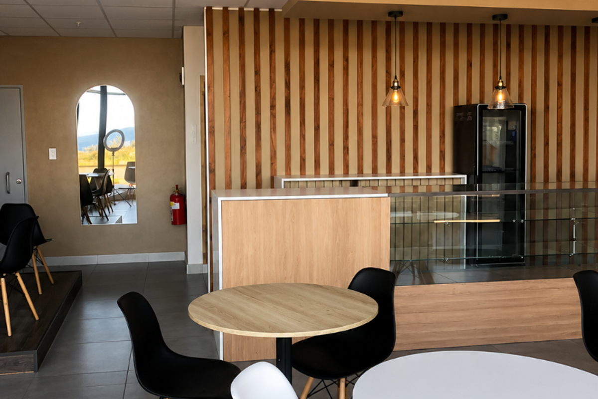Modern open-plan retail space featuring timber slat wall accents, a built-in service counter with glass display, and recessed ceiling lighting.