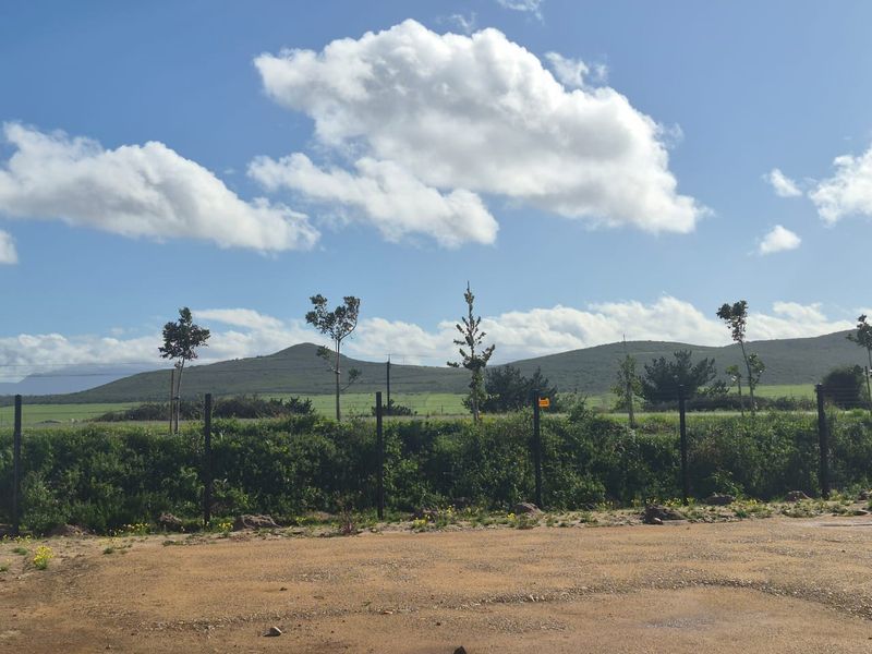 A scenic view of the surrounding hills and landscape, featuring a wire mesh boundary fence in the foreground.