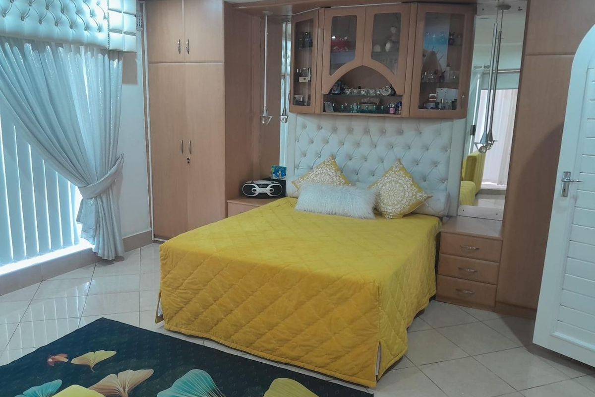 A bedroom featuring extensive built-in cabinetry, integrated headboard storage, and tiled flooring, offering a functional layout with ample storage space.