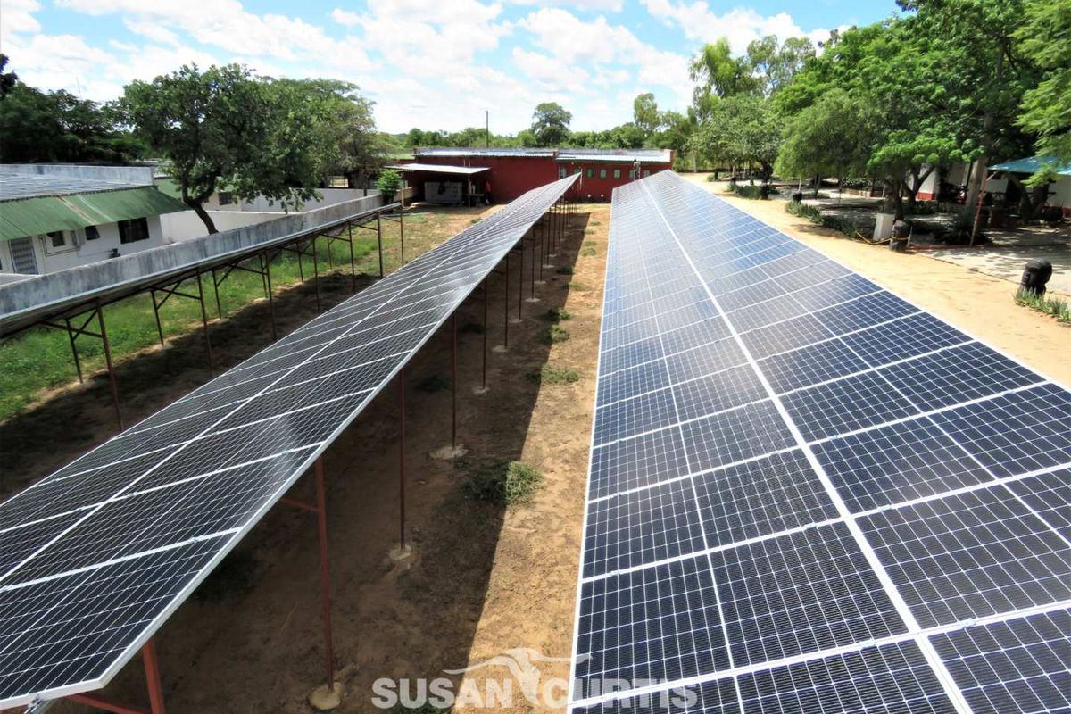 An aerial view of a large-scale ground-mounted solar panel array installation, providing sustainable energy infrastructure for the property.