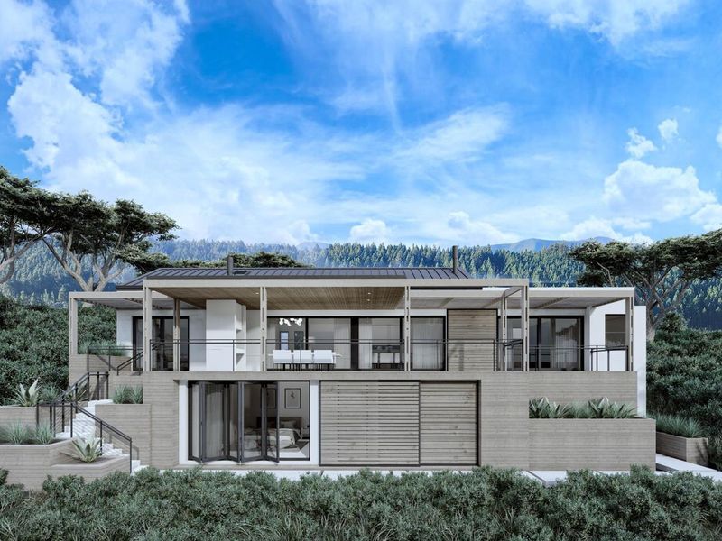 Modern architectural rear elevation featuring a spacious covered patio, bi-fold doors, and tiered landscaping set against a scenic mountain backdrop.