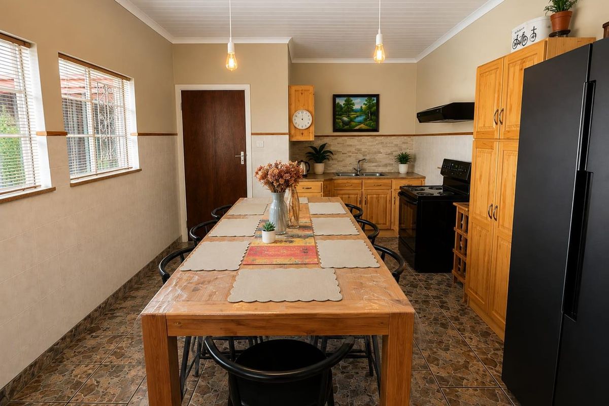 A functional kitchen featuring wooden cabinetry, tiled backsplash, double sink, and built-in pantry storage, with tiled flooring and coved ceiling details.