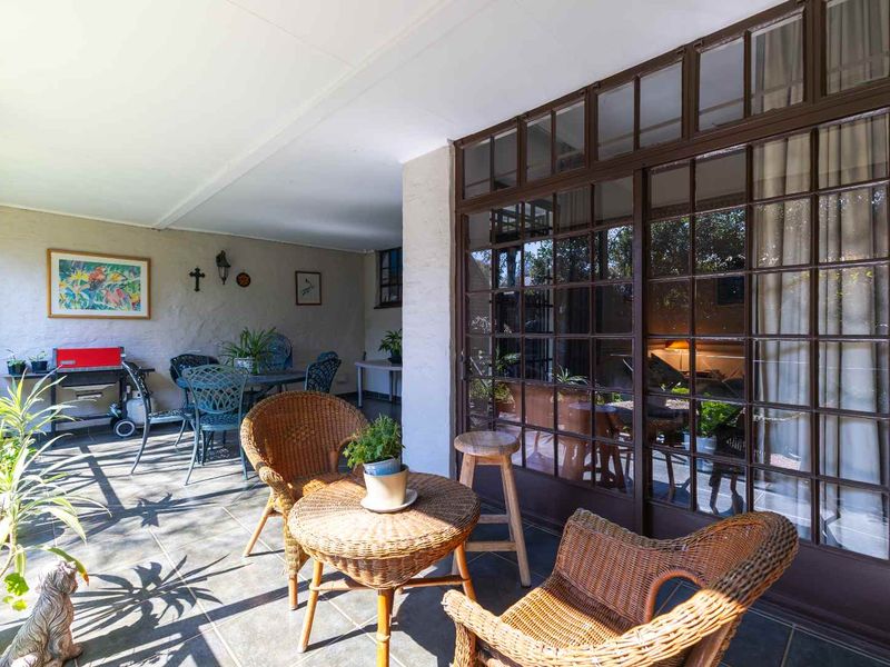 A covered patio area featuring tiled flooring and large glass sliding doors that provide seamless access to the interior living space.