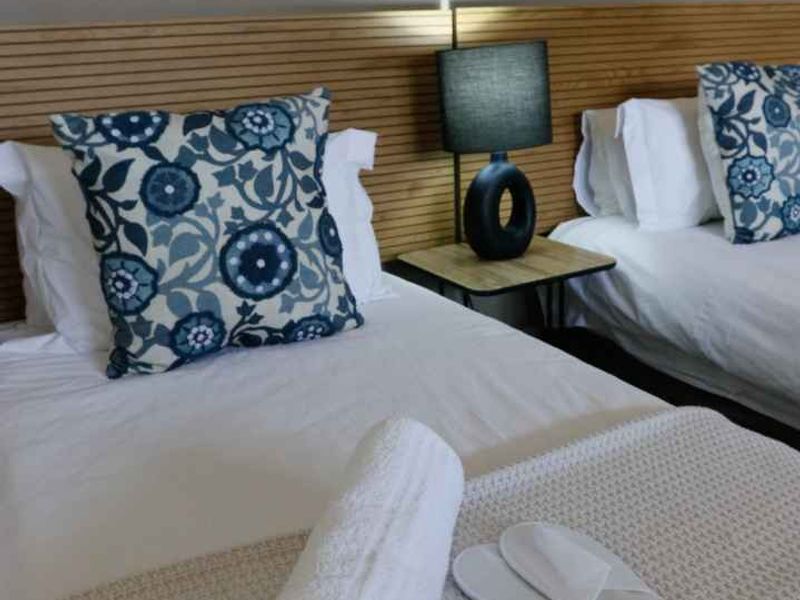A bedroom featuring a modern timber slat headboard design, providing a clean and contemporary aesthetic for the sleeping area.
