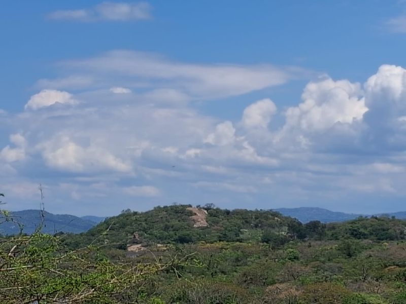 A scenic view of the surrounding natural landscape, featuring rolling hills and lush vegetation under a clear blue sky.