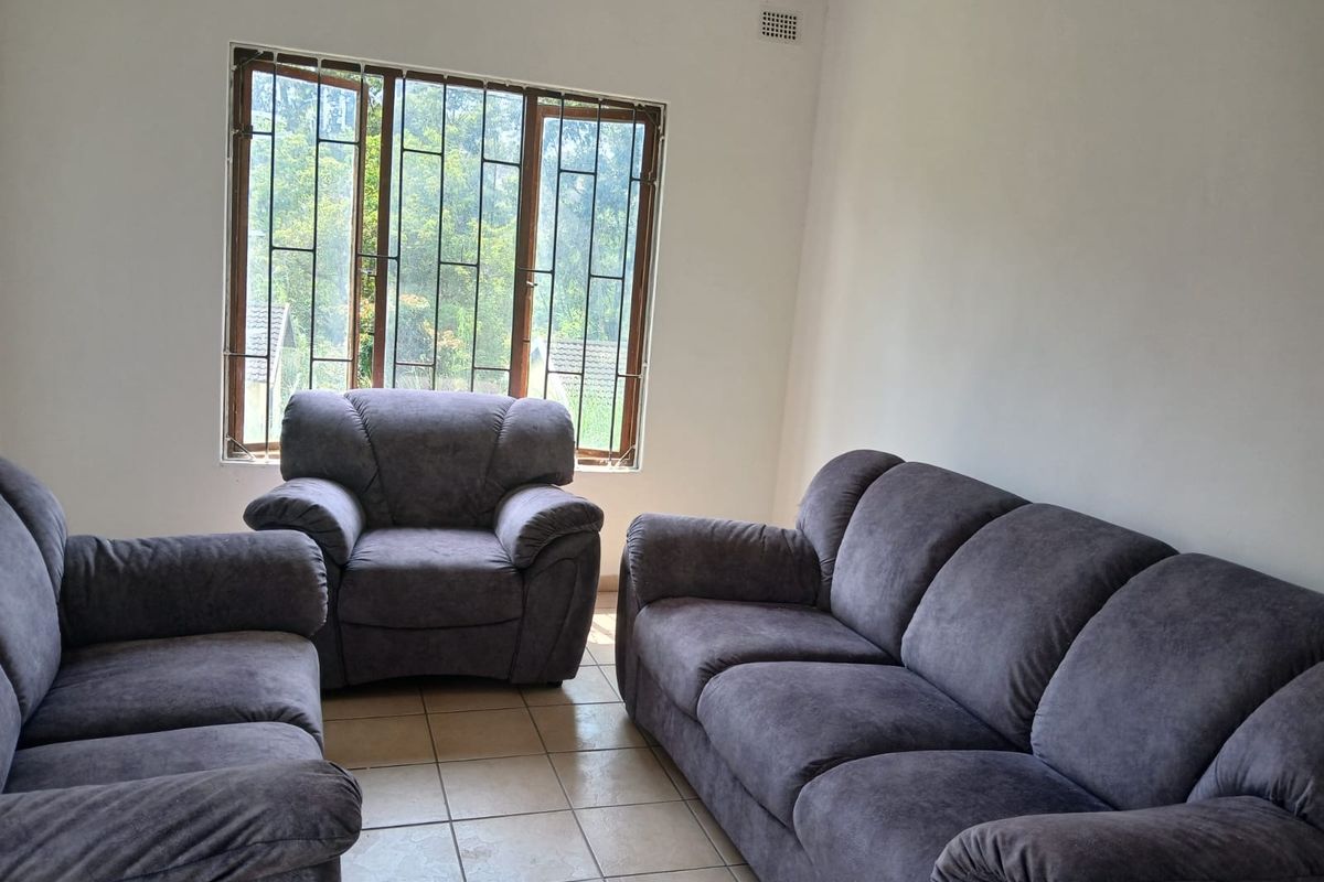 A living room featuring tiled flooring, large windows with security bars, and neutral walls, offering a functional space with potential for modernization.
