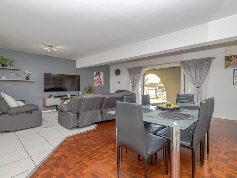 Open-plan living and dining area featuring a combination of parquet and ceramic tile flooring with direct access to the outdoor patio.