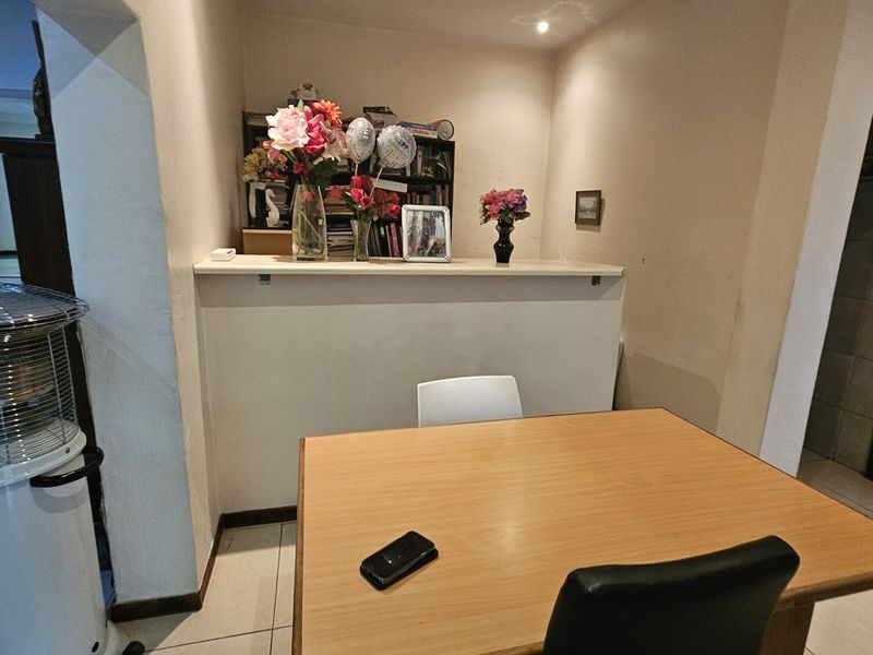 A living area featuring a built-in counter and tiled flooring, providing a functional space for daily use.