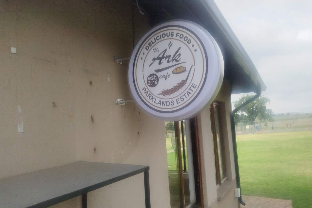 Exterior view of a commercial cafe signage mounted on the side of a building within the Parklands Estate.