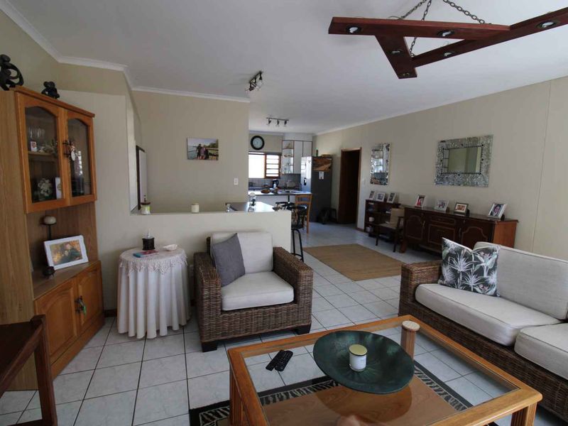 Open plan living and kitchen area featuring ceramic floor tiles and a functional kitchen layout with island bench.