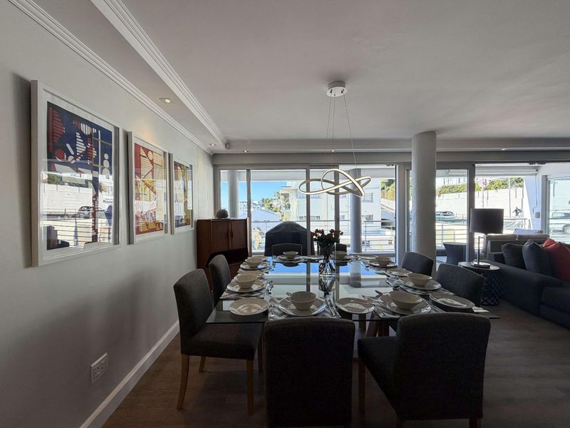 A well-lit dining area featuring crown molding, recessed lighting, and large sliding glass doors that provide natural light and access to the outdoor space.