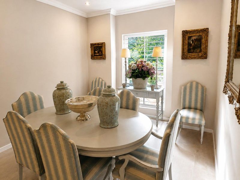 A well-maintained dining room featuring crown molding, recessed lighting, and plantation shutters, providing a bright and elegant space for formal dining.