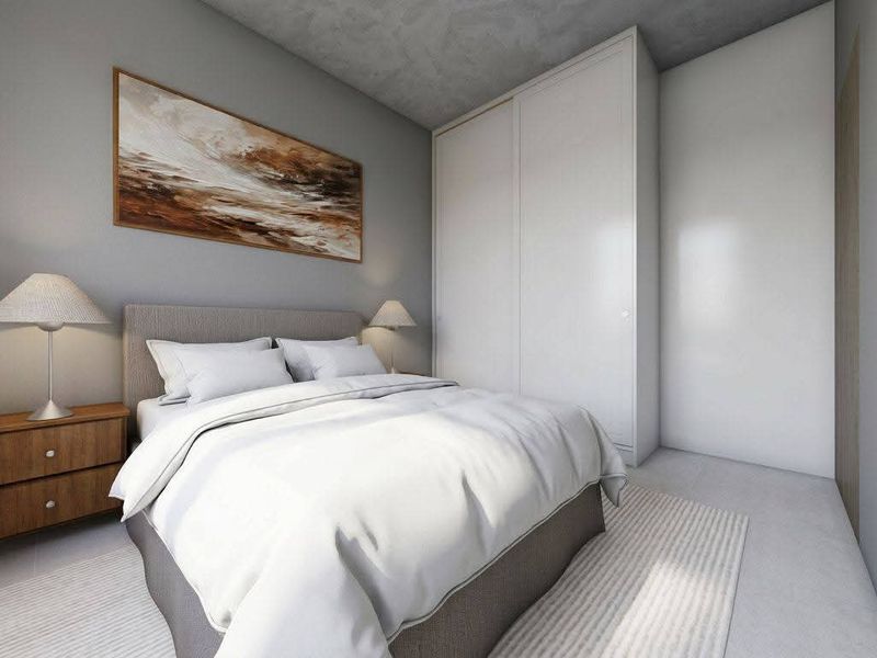 A modern bedroom featuring a built-in wardrobe and a contemporary concrete-effect ceiling finish.