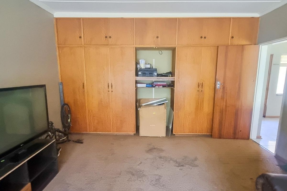 A bedroom featuring extensive built-in wooden cabinetry and overhead storage cupboards, providing ample storage space.