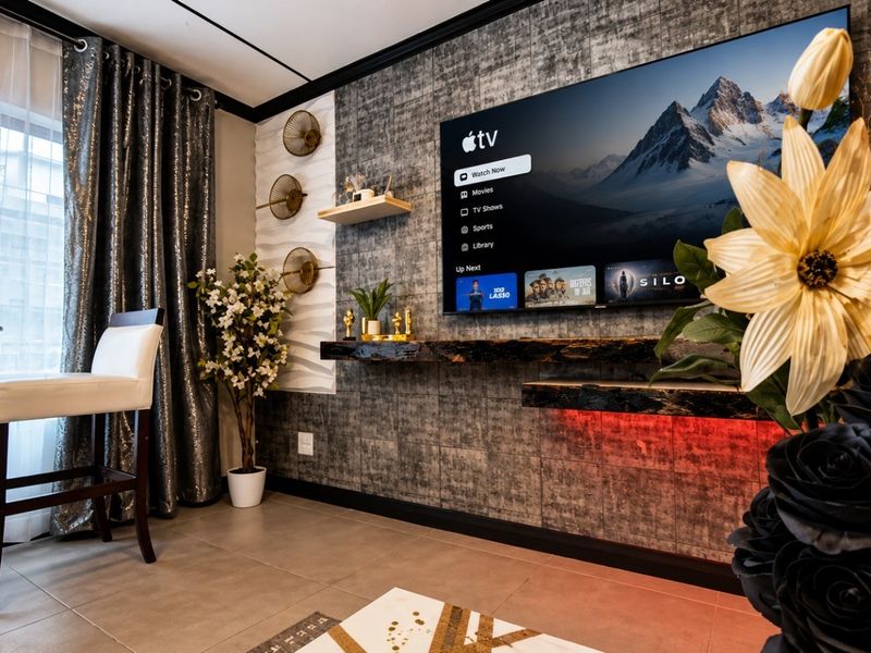 Modern living room featuring a textured feature wall, floating timber shelving with integrated LED lighting, and large windows with floor-to-ceiling curtains.