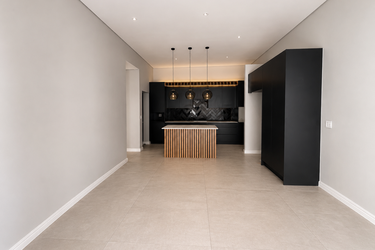 Modern open-plan kitchen featuring sleek black cabinetry, a central island with timber slat detailing, and contemporary pendant lighting.