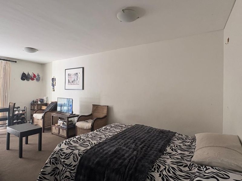 A bedroom featuring neutral walls, carpeted flooring, and a sliding glass door providing access to an outdoor area.
