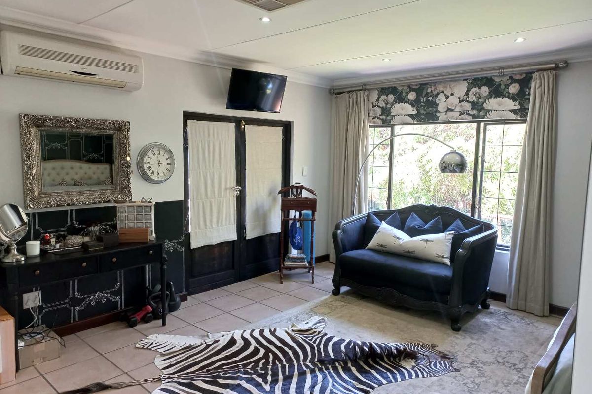 A living room featuring tiled flooring, recessed ceiling lighting, a wall-mounted air conditioning unit, and large windows with curtain treatments.