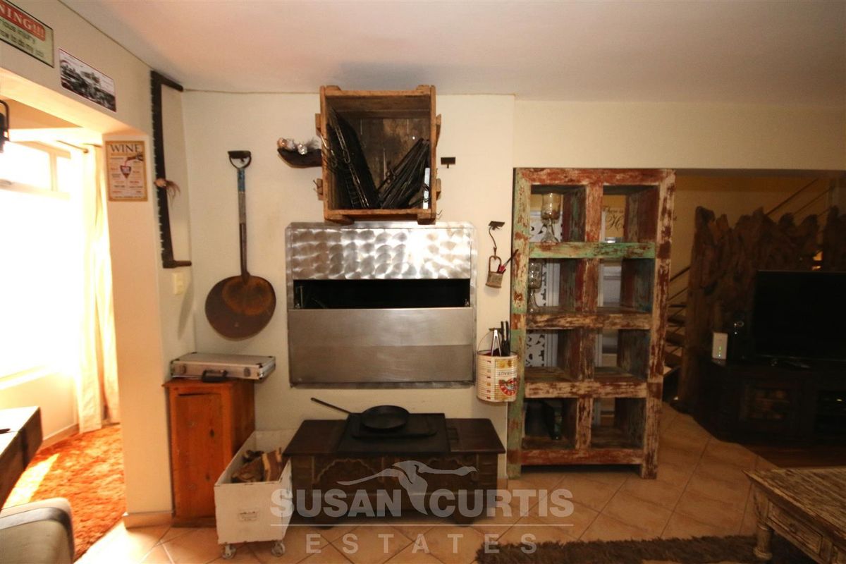 Interior living area featuring a built-in stainless steel indoor braai or fireplace with tiled flooring.