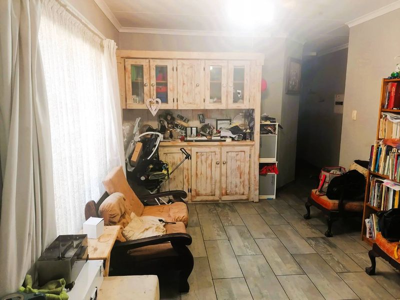 Living area featuring tiled flooring and built-in wooden cabinetry, offering potential for a refreshed and modern interior design update.