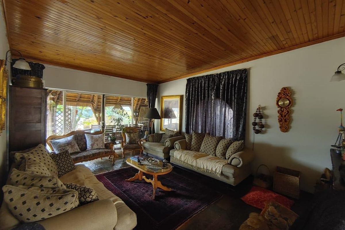 Spacious living room featuring a warm timber tongue and groove ceiling, tiled flooring, and large sliding glass doors providing access to the patio area.