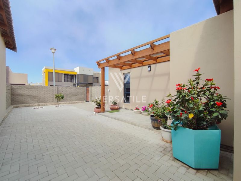A well-maintained rear courtyard featuring paved flooring and a timber pergola, providing a clean and functional outdoor space.