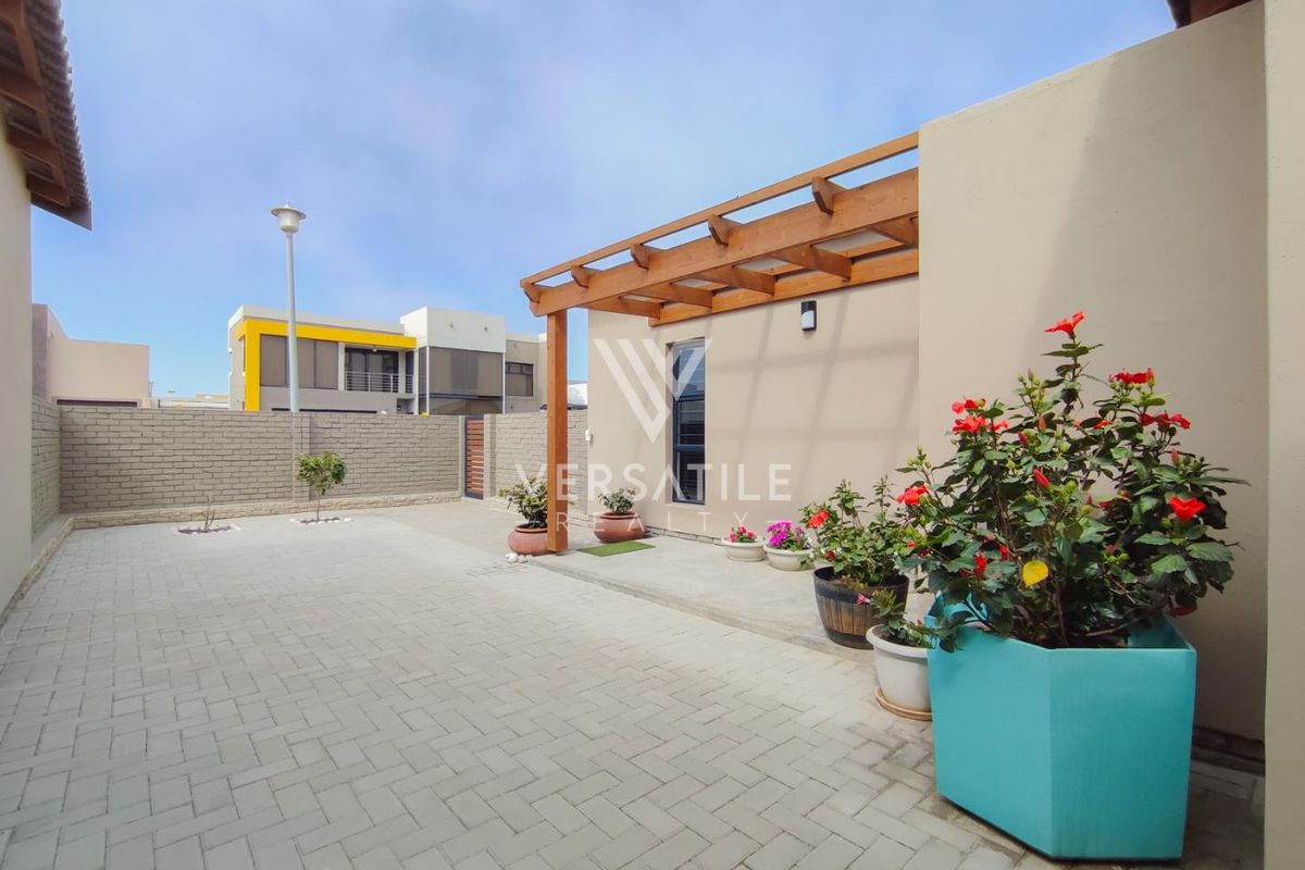 A well-maintained rear courtyard featuring paved flooring and a timber pergola, providing a clean and functional outdoor space.
