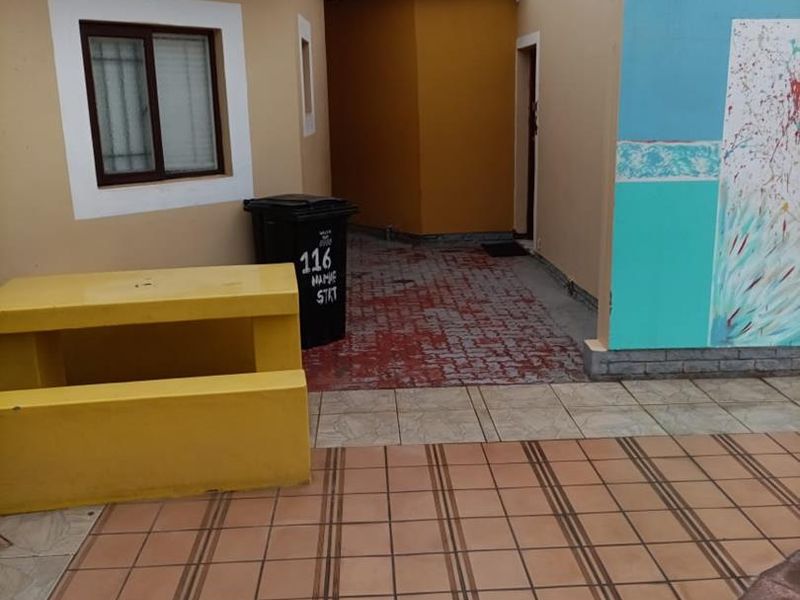 An outdoor patio area featuring tiled flooring and exterior wall finishes, providing a functional transition space between building sections.