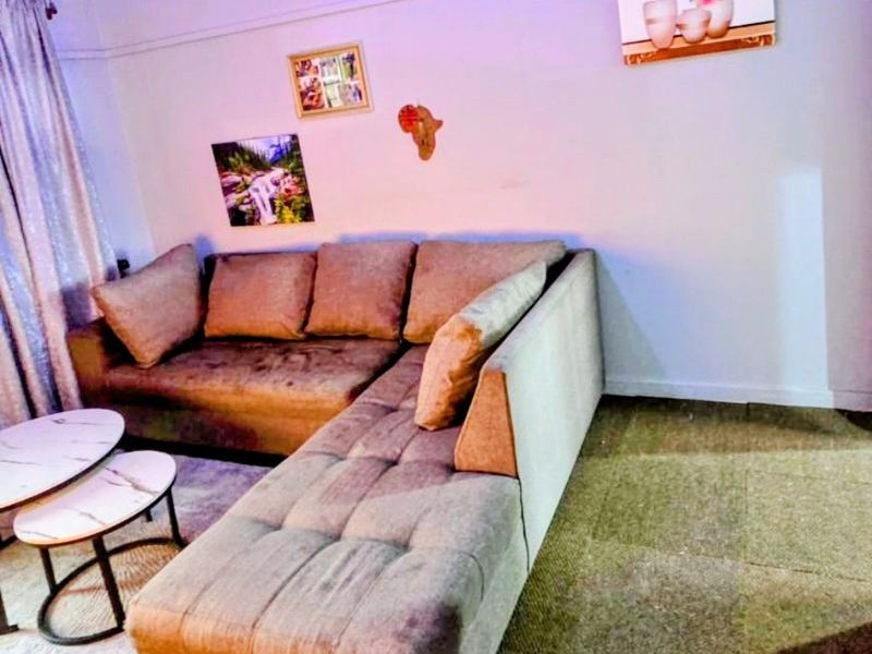 A living room area featuring neutral wall finishes and curtain rails, providing a functional space for relaxation.