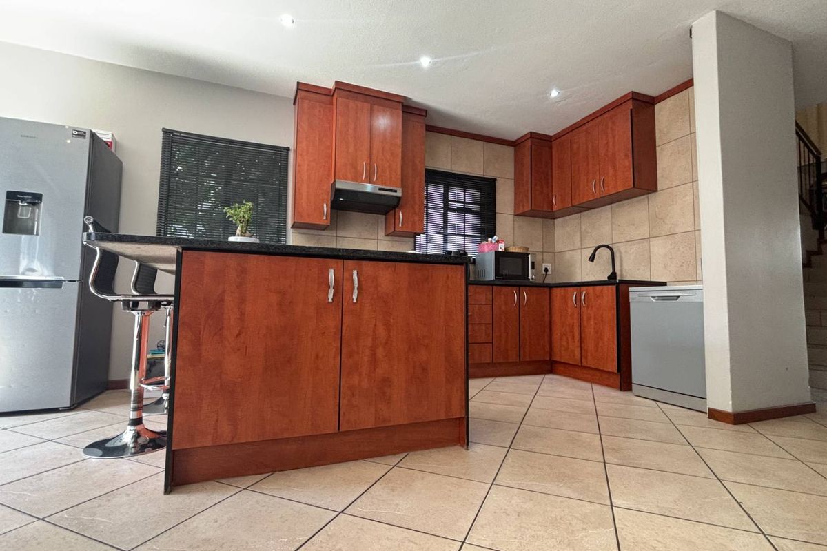 A well-maintained kitchen featuring cherry wood cabinetry, granite countertops, tiled backsplash, and recessed lighting, offering a functional and classic design.