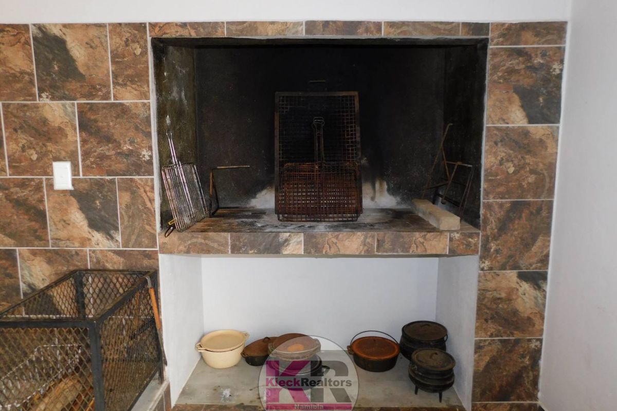 Built-in indoor braai or fireplace featuring stone-look tile surround and integrated firebox with lower storage area.