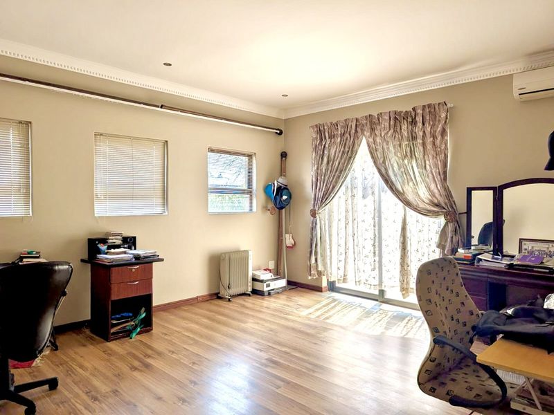 Spacious bedroom featuring laminate flooring, crown molding, recessed lighting, and a sliding glass door providing access to the exterior.