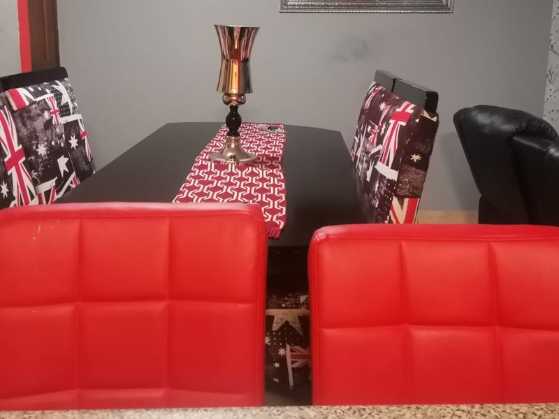 A dining area featuring tiled flooring and a decorative feature wall, providing a functional space for meals.