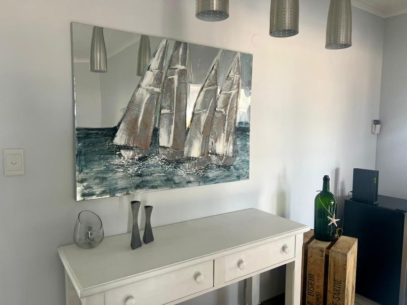 A bright interior space featuring modern pendant lighting and a neutral wall finish, suitable for a hallway or living area.