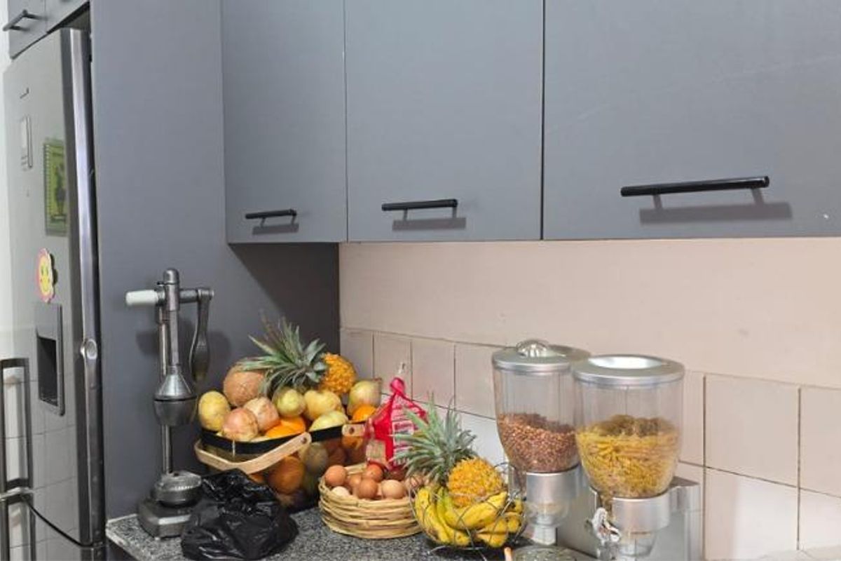 A functional kitchen area featuring modern grey cabinetry, granite countertops, and a tiled backsplash, providing a clean and practical workspace.