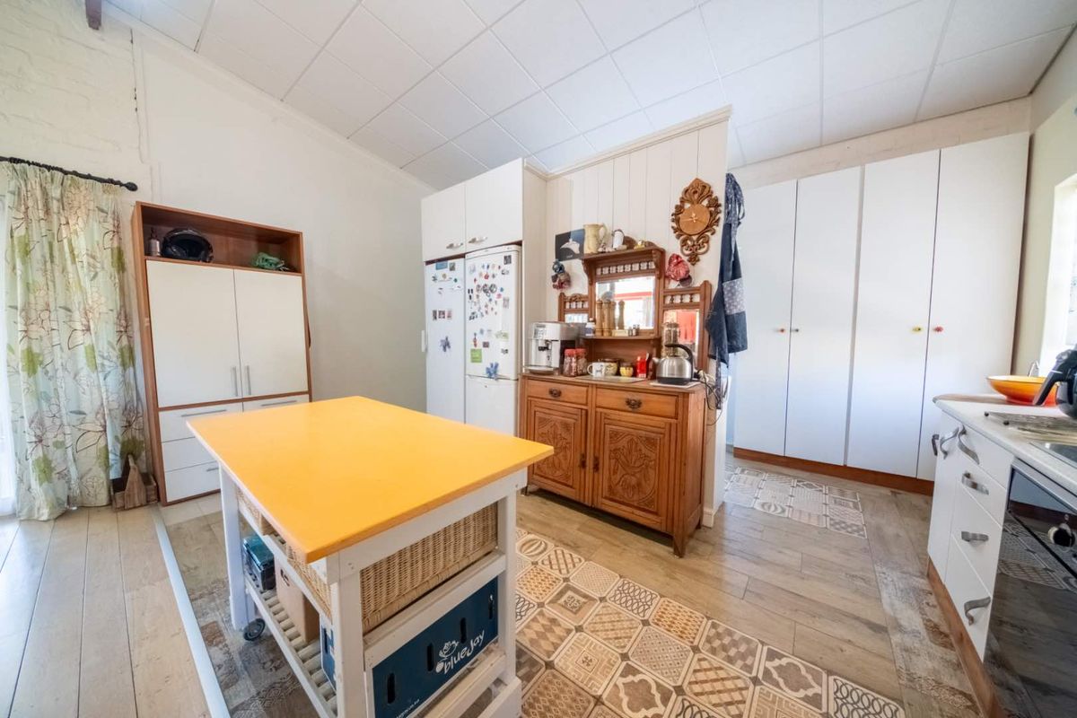 A functional kitchen space featuring built-in cabinetry, tiled flooring, and a drop ceiling, offering potential for a modern renovation.
