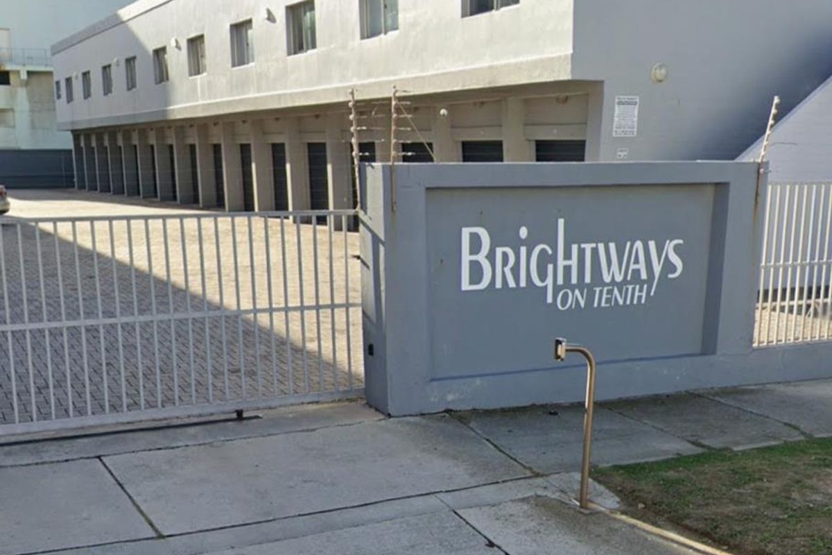 Street view of the Brightways on Tenth apartment complex entrance, featuring a secure gated driveway and row of garage units.