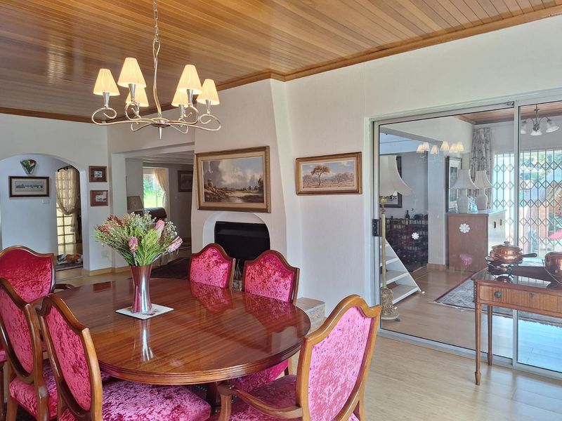 Dining room featuring a warm timber-clad ceiling, a built-in fireplace, and sliding glass doors that provide access to an adjacent living area.