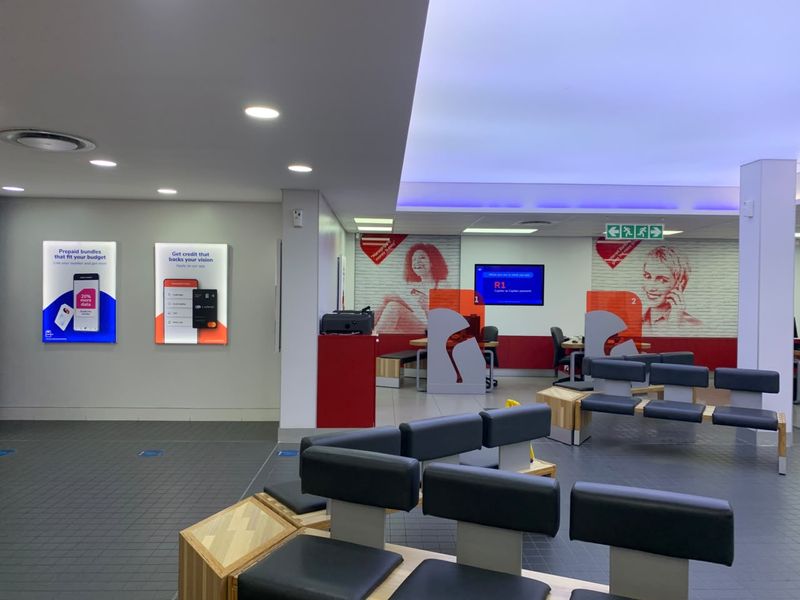 A modern, well-lit retail service area featuring tiled flooring, integrated ceiling lighting, and built-in customer service counters.