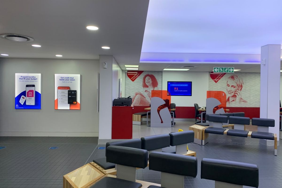 A modern, well-lit retail service area featuring tiled flooring, integrated ceiling lighting, and built-in customer service counters.