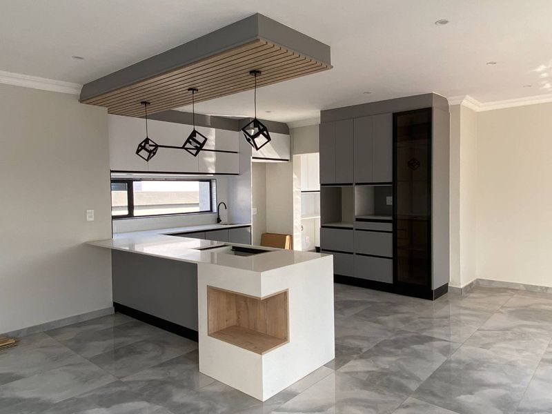 Modern, newly renovated kitchen featuring sleek grey cabinetry, a central island with quartz countertops, and a stylish slatted timber ceiling detail.