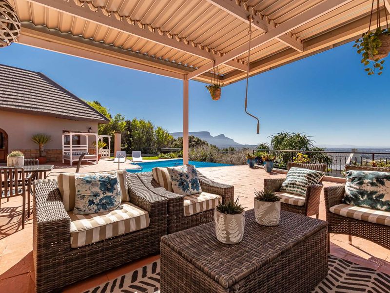Spacious covered patio featuring tiled flooring and a metal roof, overlooking a swimming pool with scenic mountain views.